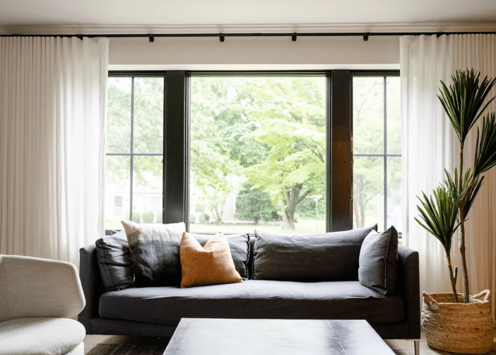 Modern living room with large window and green view.