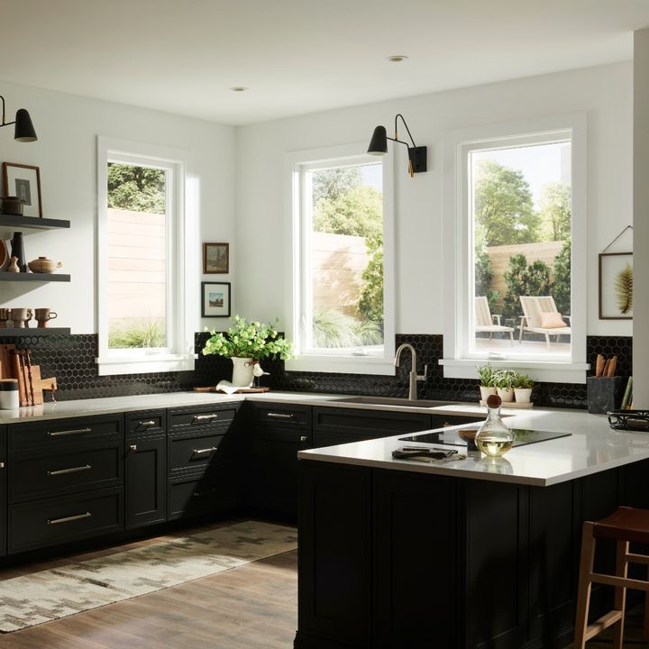Modern kitchen interior with black cabinets and natural light.