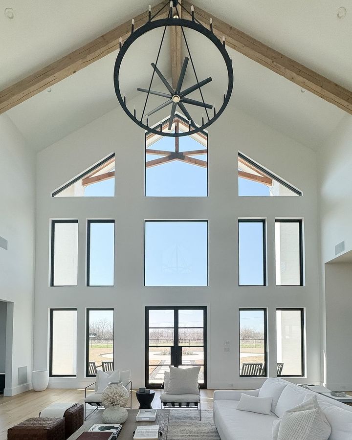 Spacious living room with large windows and ceiling clock.