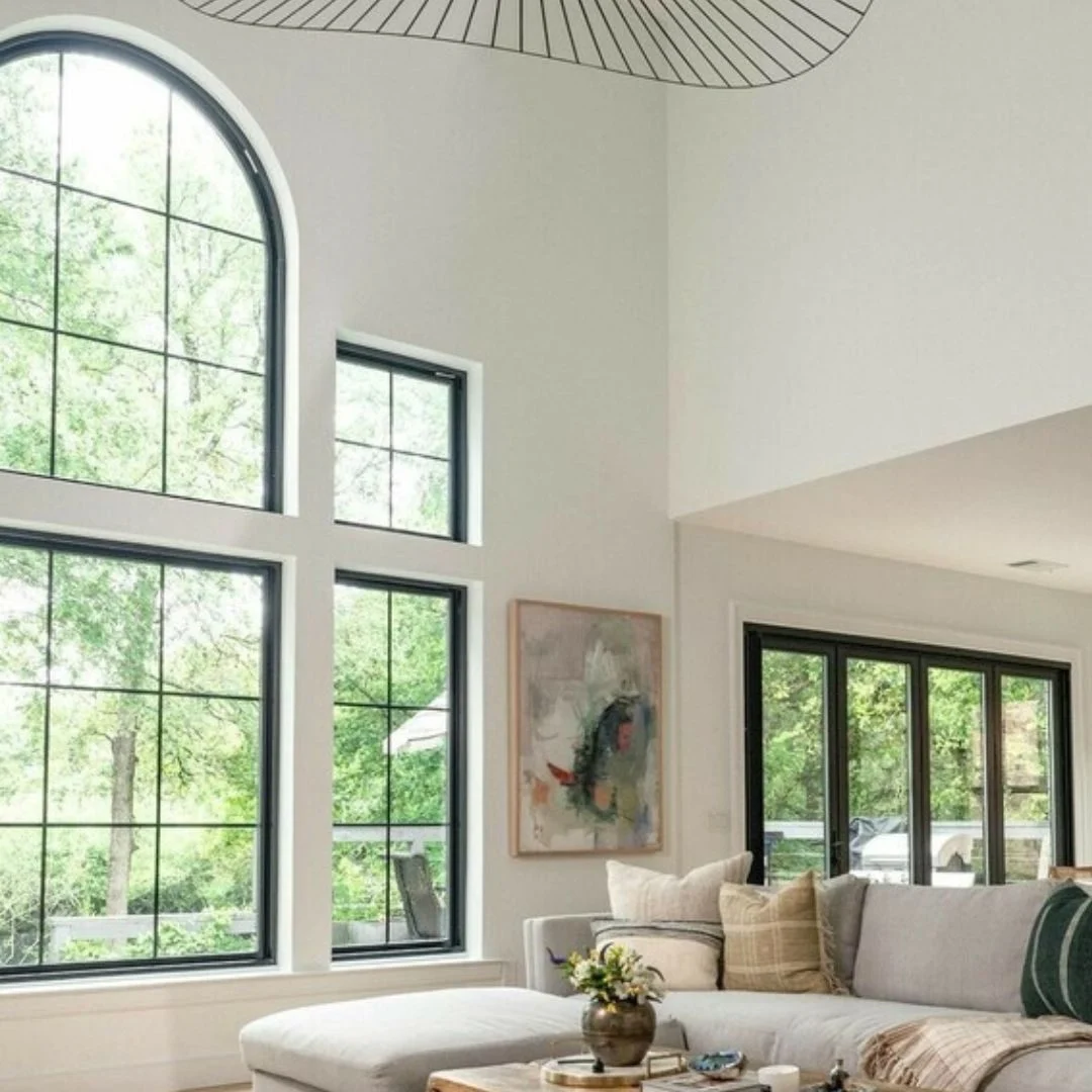 438035311_1547722332637820_201865856025527748_n Bright, airy living room with large windows and modern decor.