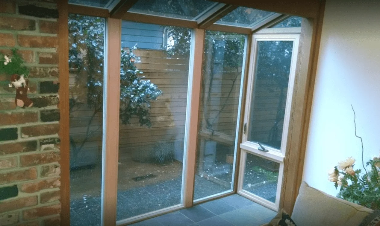 6 Sunroom with large windows and garden view.