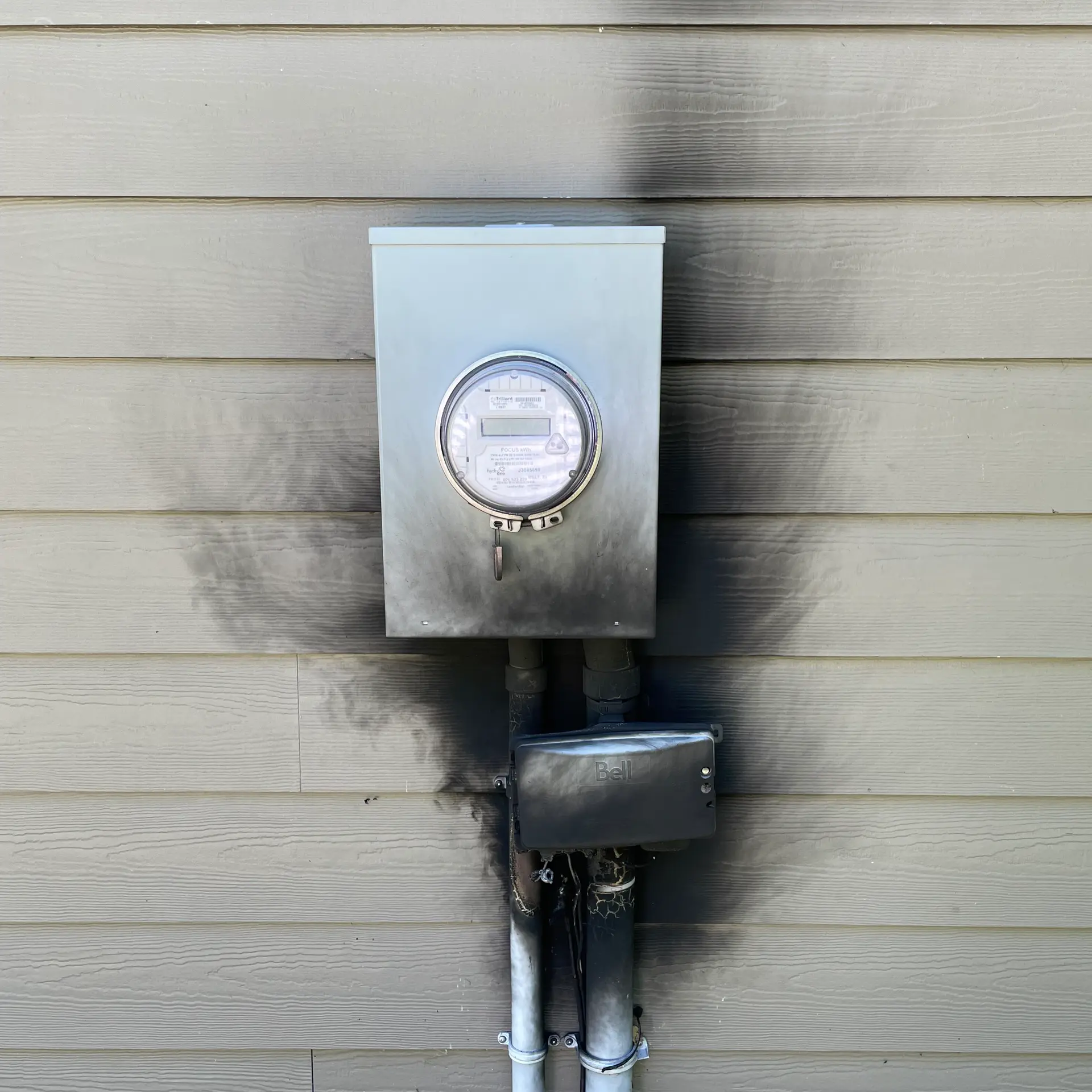 Electrical utility meter mounted on house siding