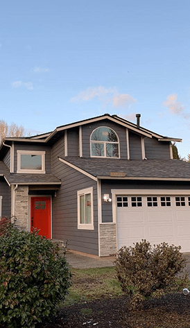 Modern two-story house with gray siding and red door