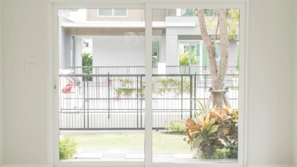 View through open doors to garden and gated home