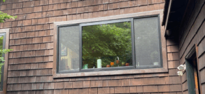 Colorful vases on window sill, wooden house exterior