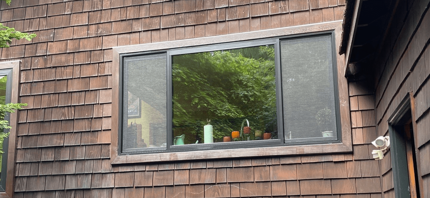 Colorful vases on window sill, wooden house exterior