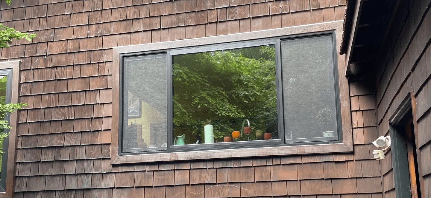 Colorful vases on window sill, wooden house exterior